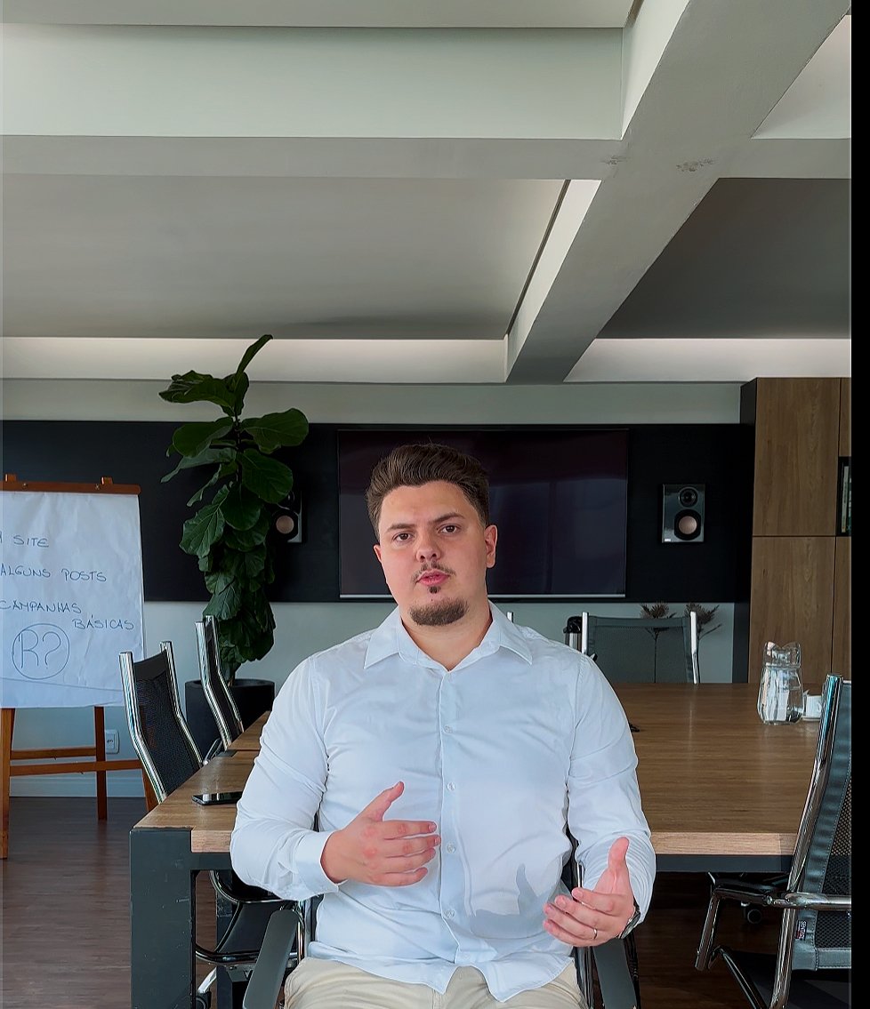 Retrato de Stefano com camisa branca em um ambiente de trabalho